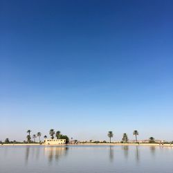 Scenic view of lake against clear blue sky