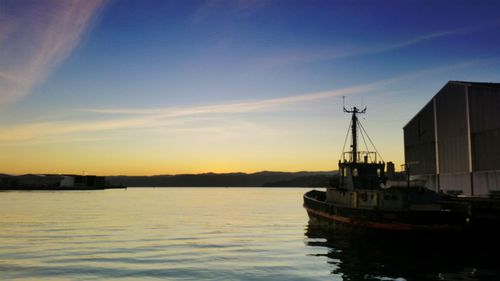 Boats in harbor at sunset