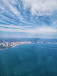 Aerial view of city by sea against sky