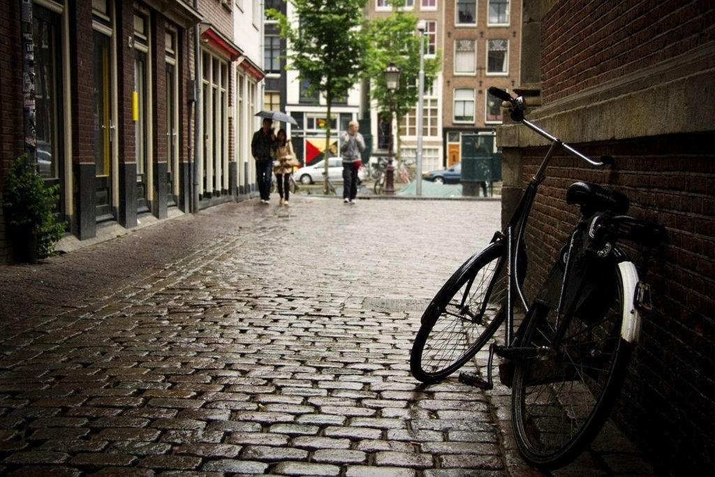 bicycle, building exterior, architecture, built structure, transportation, mode of transport, land vehicle, cobblestone, street, city, the way forward, stationary, parked, parking, footpath, building, sidewalk, diminishing perspective, residential structure, paving stone