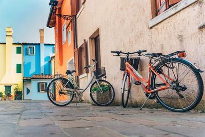 Bicycle parked on footpath by building