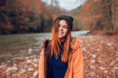 Portrait of a smiling young woman standing during autumn