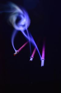 Close-up of illuminated lighting equipment against black background
