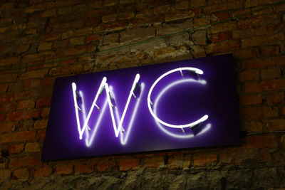 Low angle view of illuminated text on wall