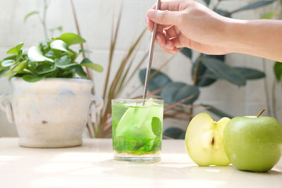 Midsection of woman holding fruit on table