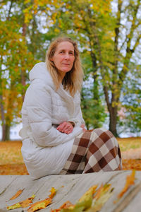 Portrait of woman sitting on tree