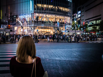 Rear view of people in city street at night