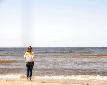 Full length rear view of man standing on beach