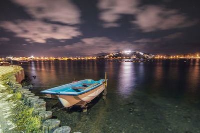 Boats moored in sea against sky at night