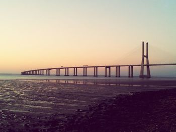 Bridge over sea at sunset