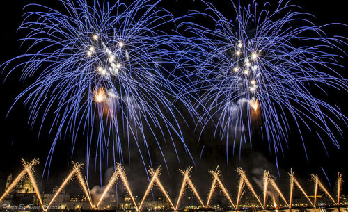 Low angle view of firework display at night