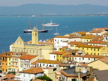 High angle view of townscape by sea against sky