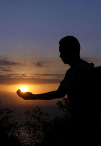 Silhouette man standing against sky during sunset
