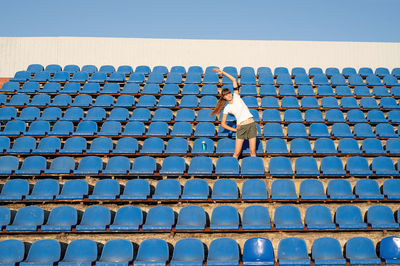 Full length of man on blue railing against sky