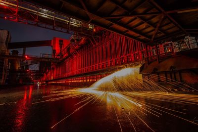 Man spinning wire wool at factory during night