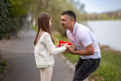 Side view of couple standing at park