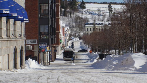 Snow covered road in city