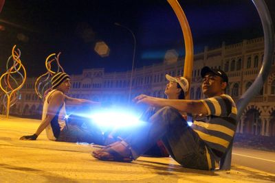 People sitting at music concert at night