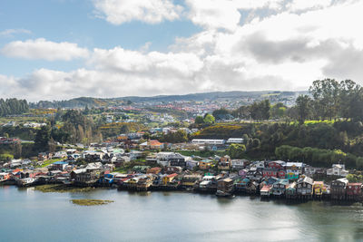 High angle view of townscape by sea against sky