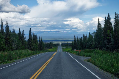 Road by trees against sky