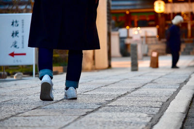 Low section of women walking on footpath