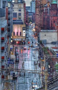 Wet street amidst buildings in city during rainy season