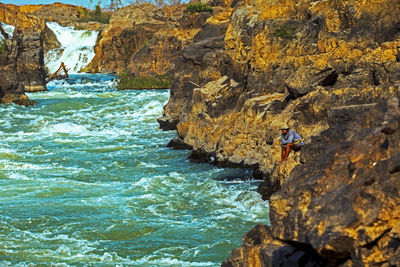 People on rock by sea