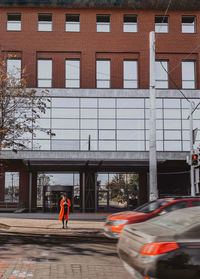Person walking on street against building in city