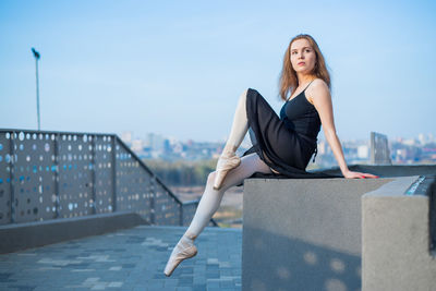 Portrait of young woman against sky