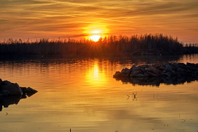 Scenic view of lake against orange sky