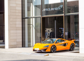 Yellow car on street against buildings in city