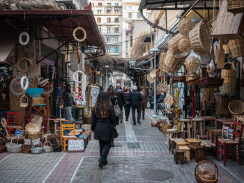 Rear view of woman walking on market stall in city