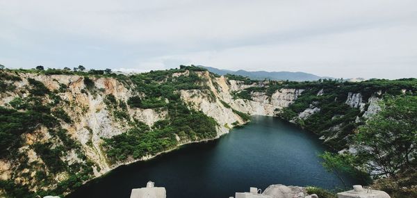 Scenic view of river amidst trees against sky