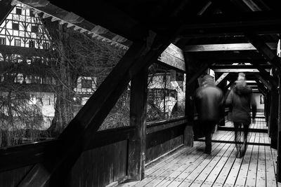 Rear view of man standing on railing in building
