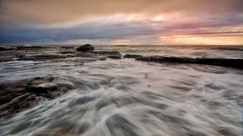 Scenic view of sea against cloudy sky