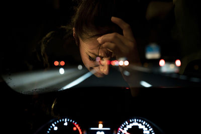 Midsection of woman in car at night