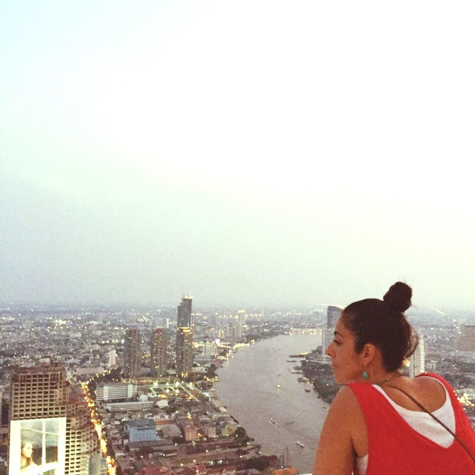 WOMAN ON CITY AGAINST CLEAR SKY