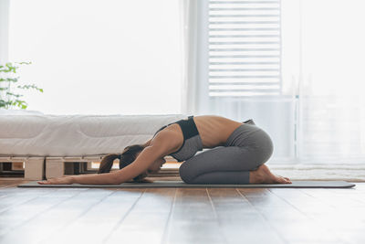 Side view of woman exercising at home