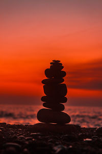 Stack of stones on beach during sunset