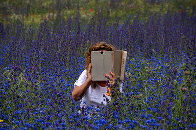 View of person holding flowering plant in field