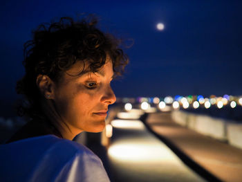 Side view of thoughtful woman looking away at night