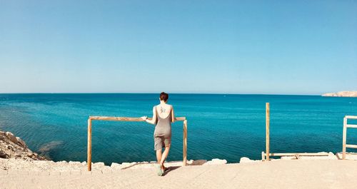 Full length rear view of man standing on beach