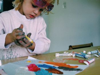 Girl holding toy on table