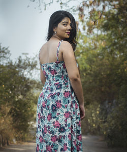 Portrait of beautiful young woman standing on dirt road