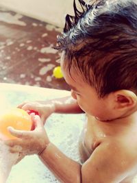 Close-up of shirtless baby boy having shower