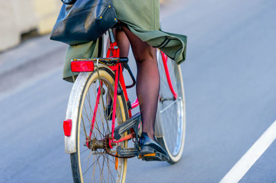 Low section of woman cycling on street