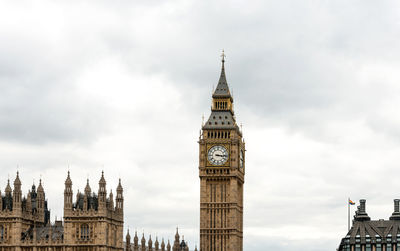 Low angle view of clock tower against cloudy sky