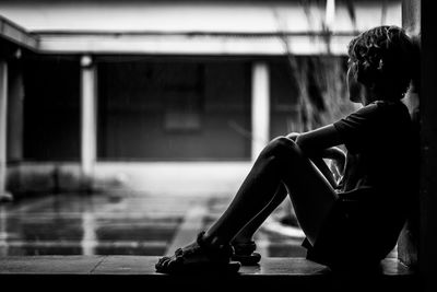 Side view of a woman sitting on floor