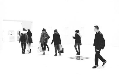 People walking on floor against white background