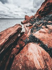 Rock formations by sea against sky